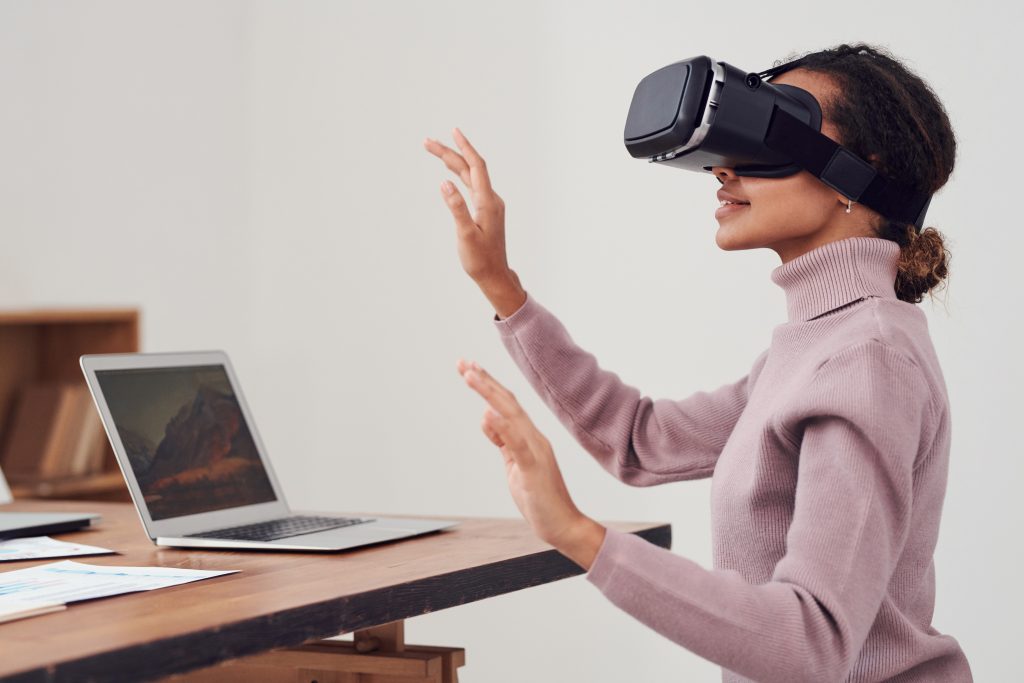 A woman wearing a VR headset is taking a learning and development course at work.